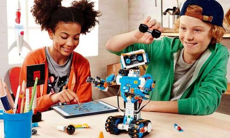 Schoolkids using a tablet to build a robot together